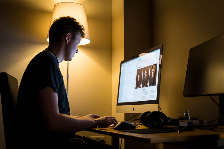 Kelvin (the guitarist) sitting at a desk coding the website