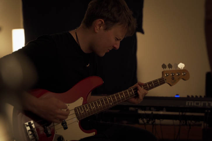Kelvin playing bass in a dark bedroom music room