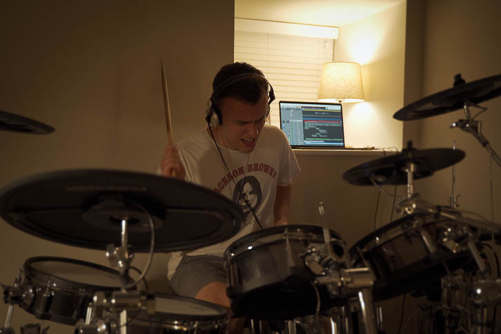 Gavin recording drums in a dark bedroom music room